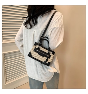 Vue détaillée de la texture du tissu tissé et de l'anse en cuir noir du sac bandoulière