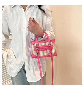 Détails d'un mini sac à main tissé rose avec des glands et des boucles de ceinture