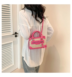 Détail du mini sac bandoulière en cuir rose et tissage beige porté par un mannequin