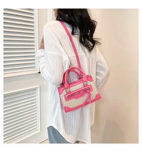 Pink and beige woven crossbody bag worn by model, showing size and summer styling