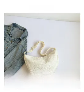 Close-up of white crescent shoulder bag featuring unique bubble pleated texture and strap