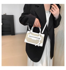 Close-up of mini white leather and woven fabric crossbody bag with decorative metal zipper