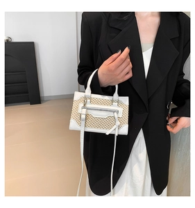 Détail du sac à main en cuir et paille avec fermeture éclair argentée et cordon