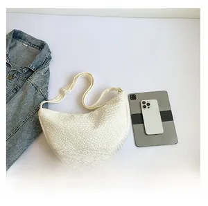 Detailed comparison of off-white crescent tote bag size next to a tablet and denim jacket