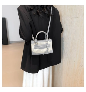 Vue détaillée du sac bandoulière tissé bicolore avec franges et fermeture éclair