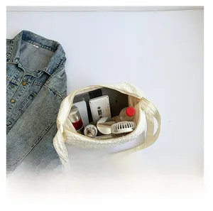 Spacious interior of white pleated tote bag showing daily items like a fan and bottle