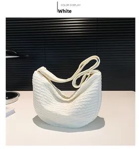 Detail view of the white pleated dumpling bag with unique bubble texture and wide strap