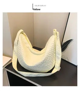 Detail of yellow crescent tote bag with bubble pleat texture and wide shoulder strap
