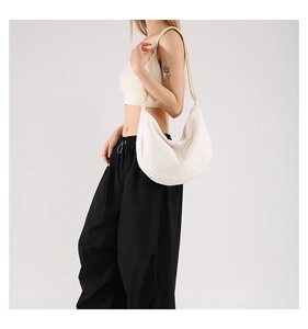 Detail of white bubble texture fabric on a stylish crescent-shaped crossbody bag for women