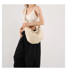Detailed texture of off-white pleated hobo bag fabric with minimalist wrinkled design