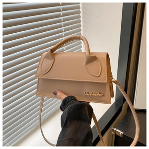 Detailed shot of beige leather crossbody bag with elegant gold logo and top handle