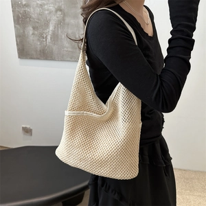 Chic beige mesh woven shoulder bag with white trim shown in a minimalist studio setting
