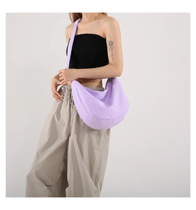 Close-up of lilac half-moon crossbody bag featuring unique textured fabric and wide strap