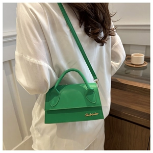 Vista dettagliata della borsa in pelle verde brillante con logo in metallo dorato