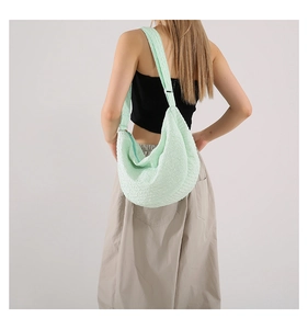 Detail of mint green crescent bag with textured bubble fabric and wide strap