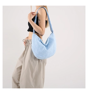Detail of sky blue crescent bag with bubble texture and wide shoulder strap