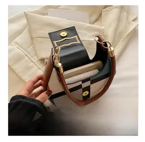 Detail showing the internal storage capacity of the plaid saddle bag with phone and wallet