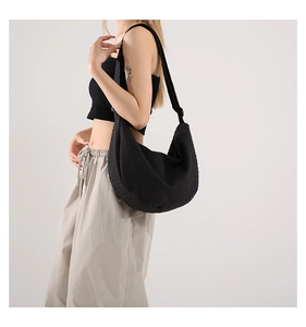 Detailed view of large black crescent tote with woven geometric texture and wide strap