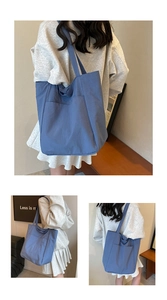 Detail of blue waterproof oxford tote bag featuring front pocket and textured surface