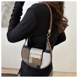 Chic patchwork crescent shoulder bag with canvas and leather details shown on model