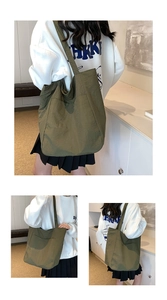 Detail of olive green nylon tote bag with pleated texture and functional front pocket