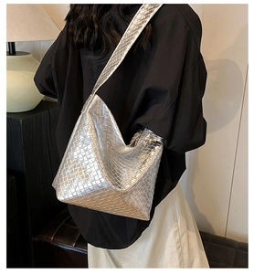 Detail der silbernen gewebten Hobo-Tasche mit kompliziertem Metallic-Gittermuster und Träger