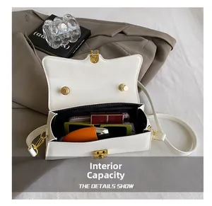 Interior view of small white leather crossbody bag showing space for phone and makeup