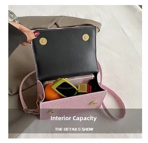 Detail van de roze geweven crossbodytas met dubbele gouden magnetische sluitingen