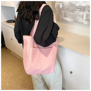Pink tote bag detail showing textured oxford fabric and large functional front pocket