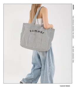 Détail du grand sac cabas en toile rayée avec imprimé Summer porté à l'épaule