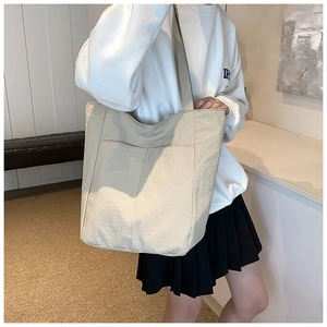 Detail of minimalist beige oxford tote bag with large front pockets and wrinkled texture
