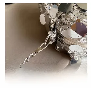 Detail of silver sequin bag showing high-quality metal hook, chain strap and zipper