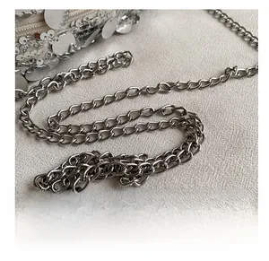 Close-up of polished silver metal chain strap and shiny sequins on fashion handbag