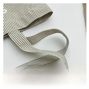 Détail de la large bandoulière en toile d'un sac cabas rayé pour un meilleur confort