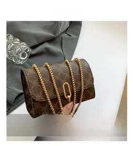 Detailed view of women's vintage brown crossbody bag with floral pattern and gold clasp