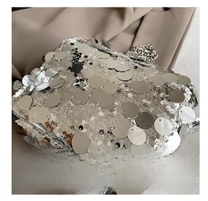 Macro detail of silver sequins and metal chain strap on a trendy women's crossbody bag
