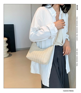 Gros plan du sac hobo tissé crème avec texture en V porté par un mannequin femme