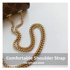 Close-up of golden box chain strap and retro clover pattern on small square bag