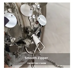 Detailed close-up of smooth silver zipper and shimmering sequins on a stylish bag