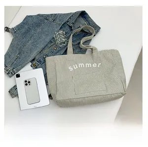 Vue à plat d'un grand sac fourre-tout en toile rayée avec imprimé Summer et accessoires