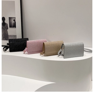 Vier glitzernde Umhängetaschen in Schwarz, Rosa, Gold und Silber auf weißem Kunstdisplay