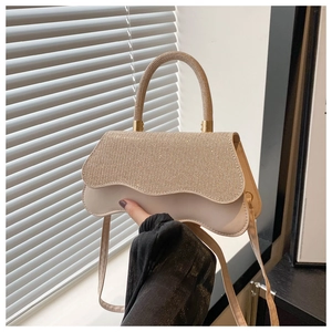 Dettaglio della patta glitterata e della texture in ecopelle crema sulla borsa moda