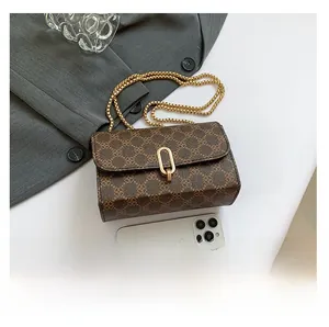 Brown monogram crossbody bag compared with smartphone showing compact portable size