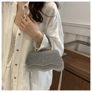 Detail of silver rhinestone handbag with wavy cloud edge and slim shoulder strap