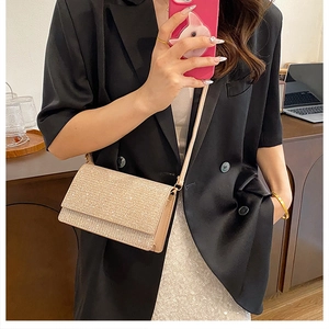 Detailansicht einer goldenen Pailletten-Umhängetasche über einem schwarzen Blazer