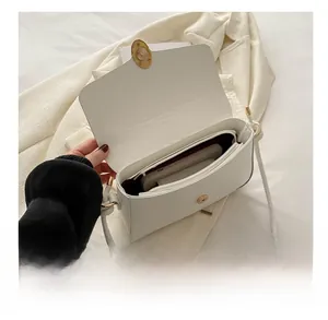 Vue de dessus montrant le compartiment intérieur spacieux et le fermoir doré du sac blanc
