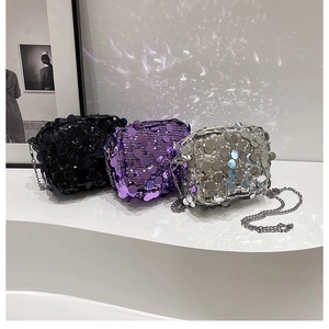 Close-up of glittery sequin mini bags in black, purple, and silver with metal chains