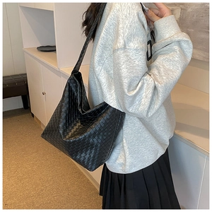 Detail einer großen schwarzen Hobo-Tasche aus geflochtenem Leder mit Textur