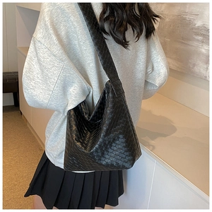Detailansicht der schwarzen gewebten Hobo-Tasche mit Textur und Schultergurt am Modell