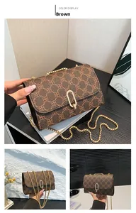 Detailed close-up of brown crossbody bag featuring retro monogram and gold oval lock